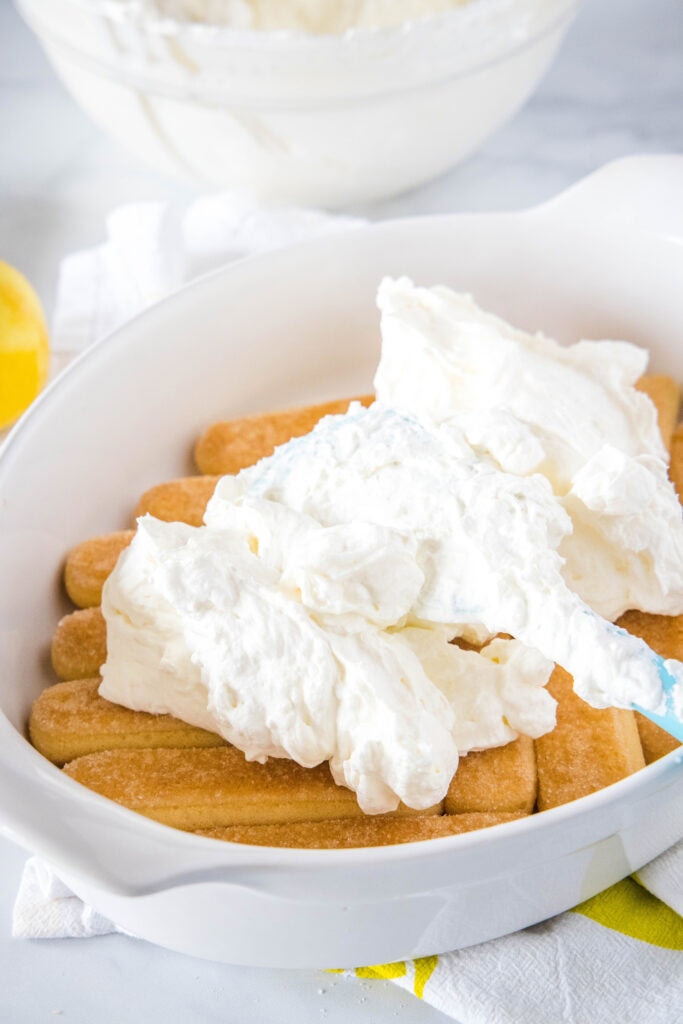 spreading cream over lady finger layer