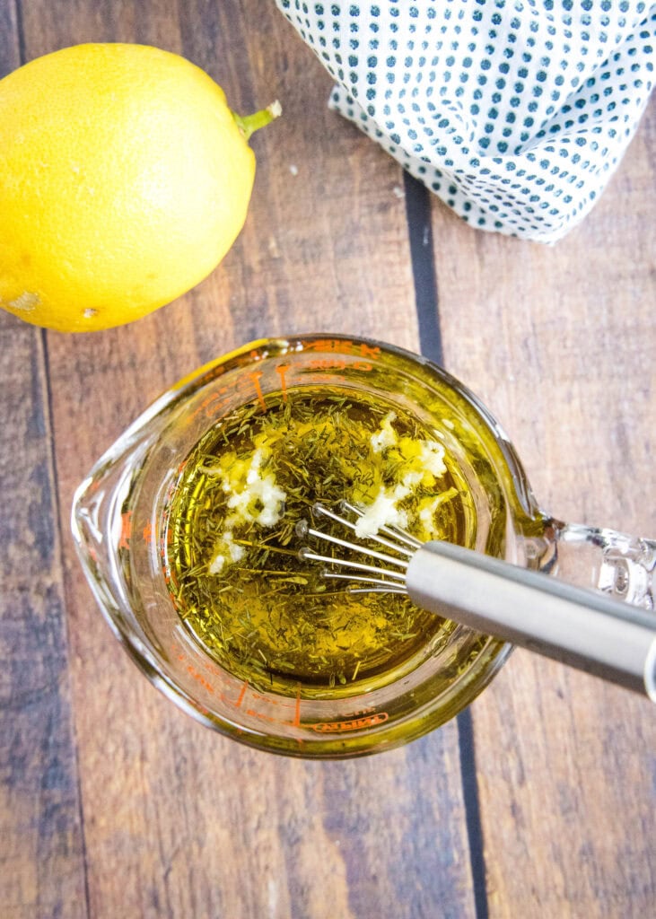 ingredients in measuring cup for lemon dressing