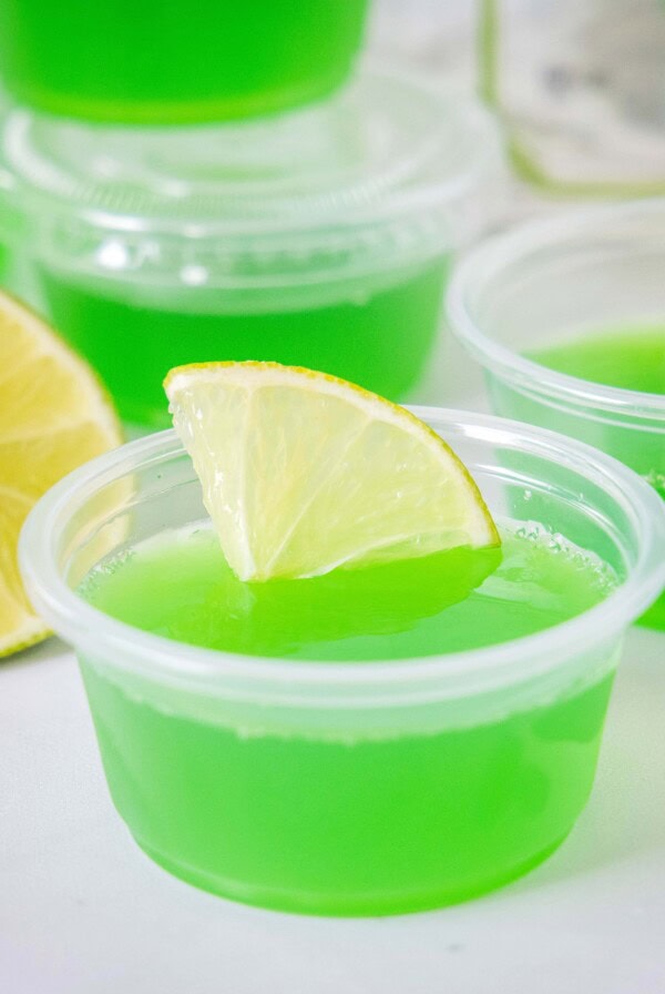 close up margarita jello shots with a slice of lime