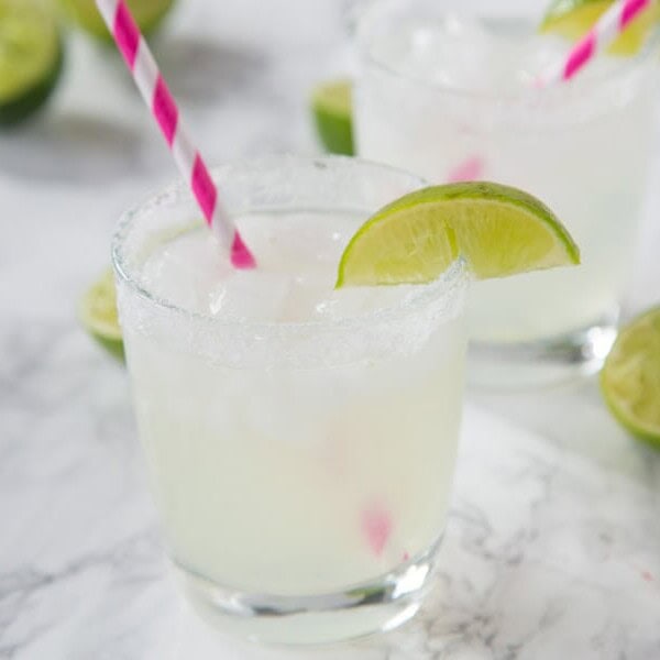 margarita in a glass with lime wedge and pink straw