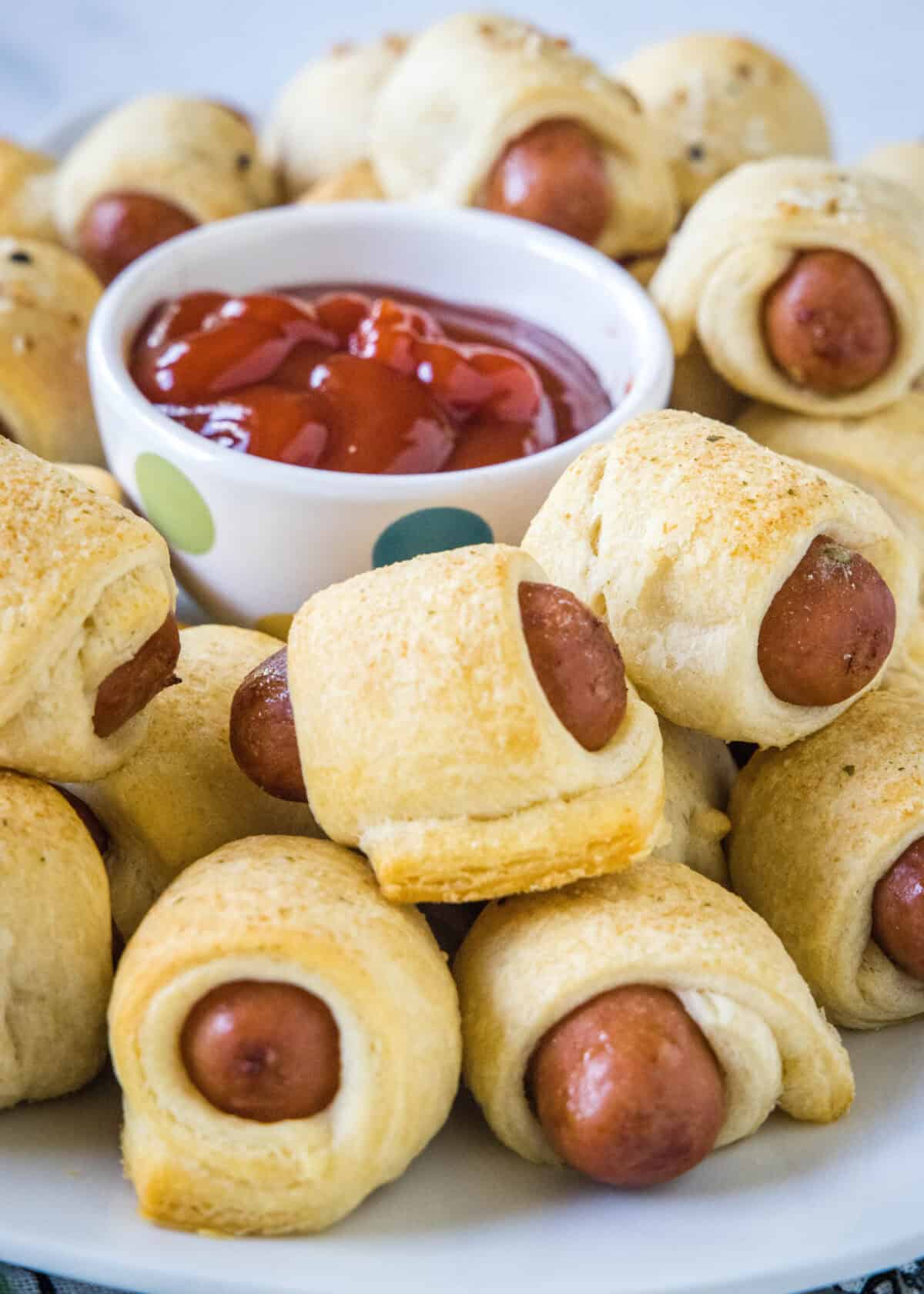 pigs in a blanket on a plate with ketchup