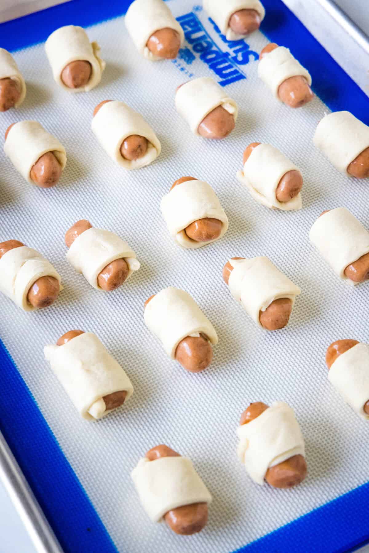 pigs in a blanket on baking sheet ready for the oven
