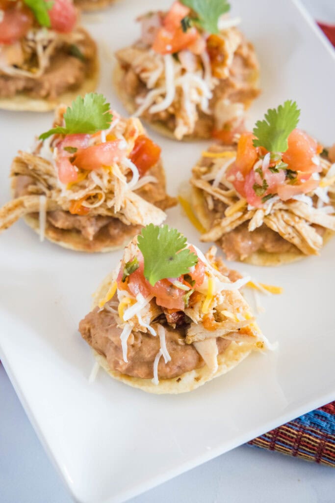 a plate with mini tostadas arranged on it