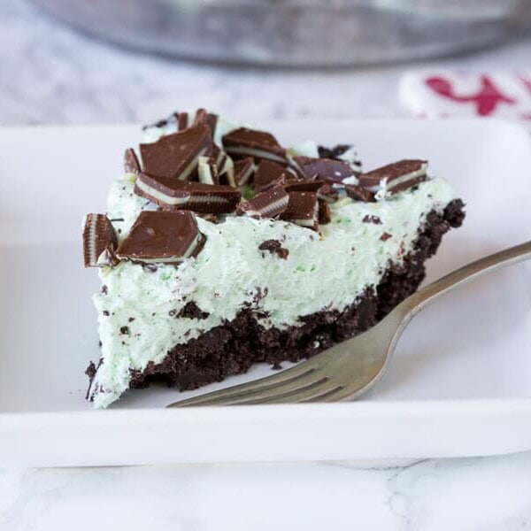 No Bake Mint Chocolate Chip Pie - a creamy mint pie with chocolate chips, topped with Andes mints, all in an Oreo crust! Such an easy no bake recipe for those hot days.
