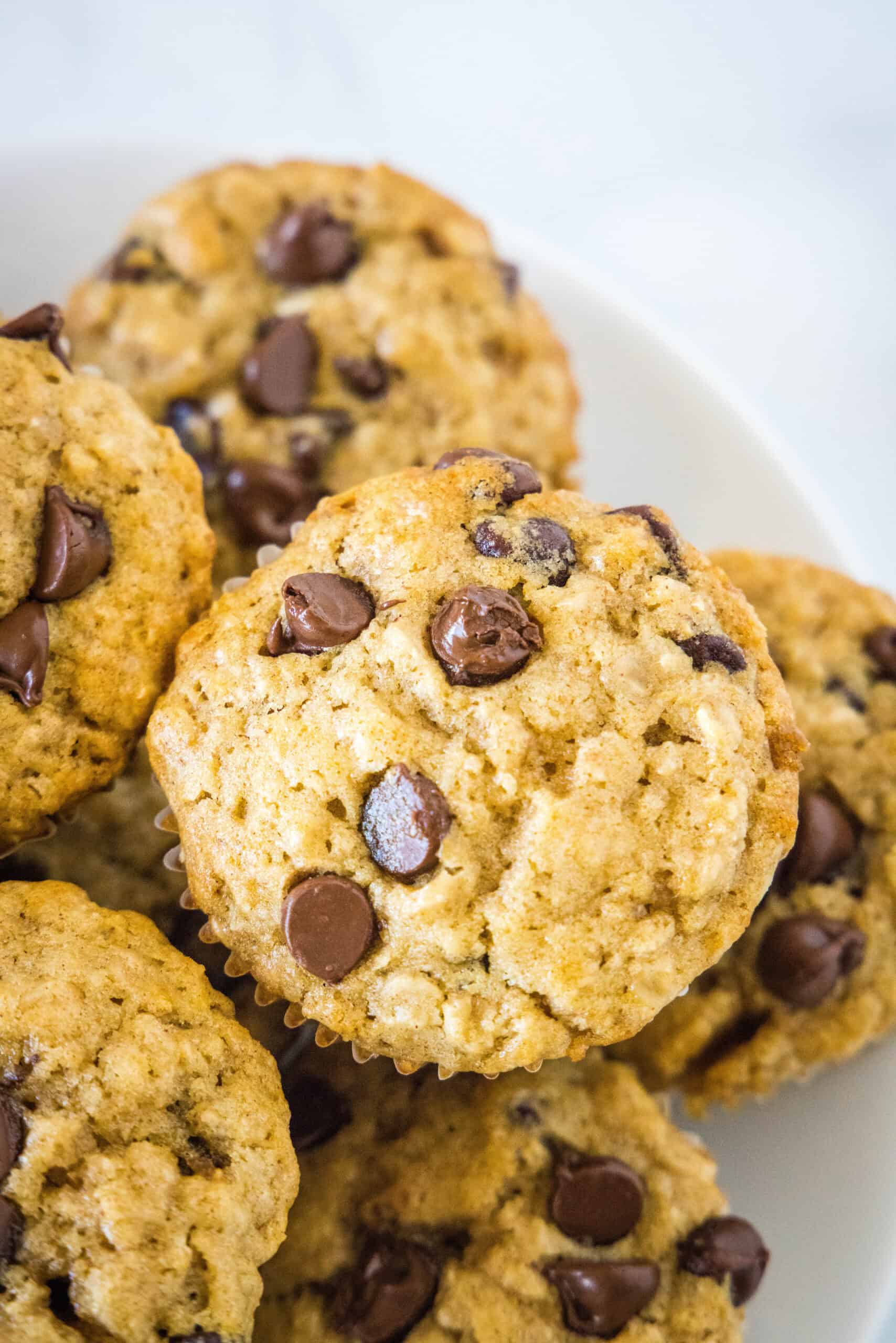 Close up of oatmeal chocolate chip muffins piled on a plate.