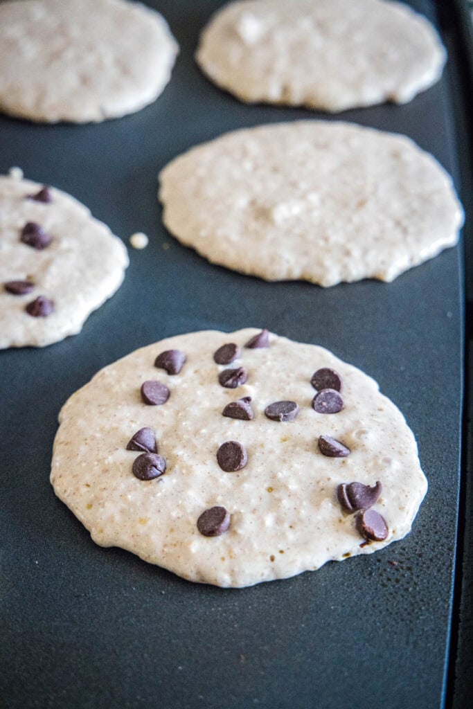pancakes cooking on a griddle