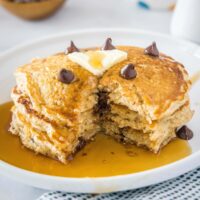 cropped close up pancakes with a bite missing on a white plate