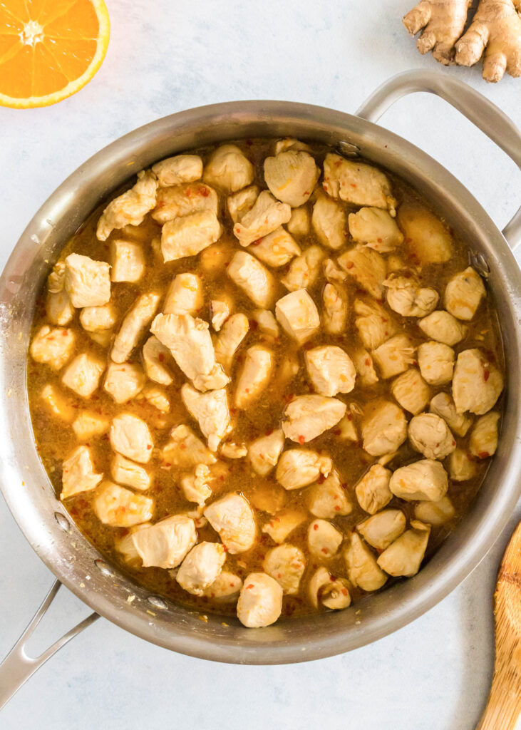 orange chicken in a skillet cooking
