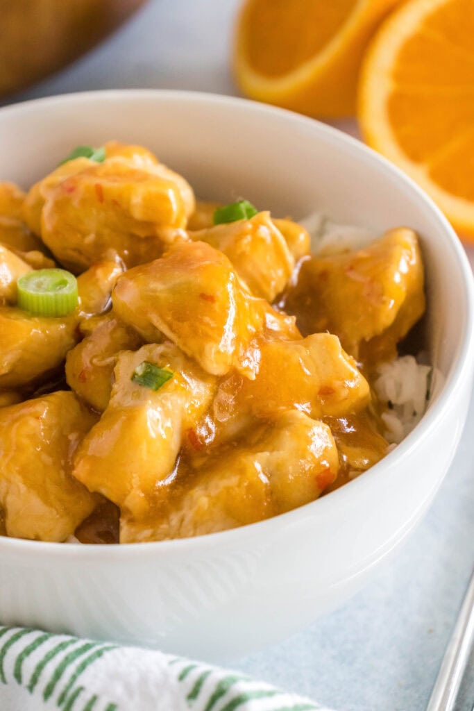 a bowl of rice topped with orange chicken