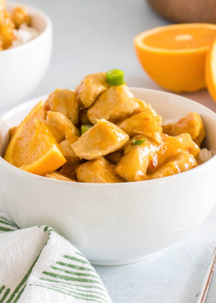a white bowl with orange chicken