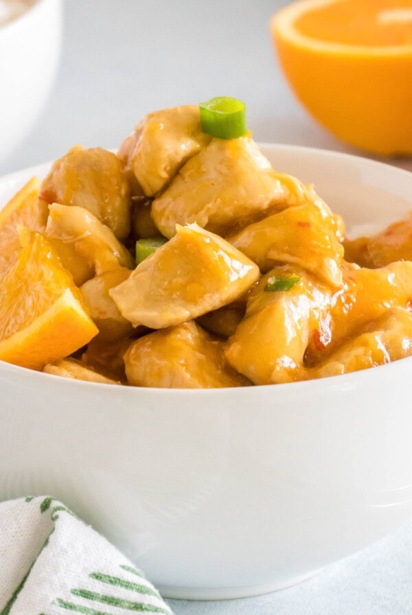 close up orange chicken in a white bowl
