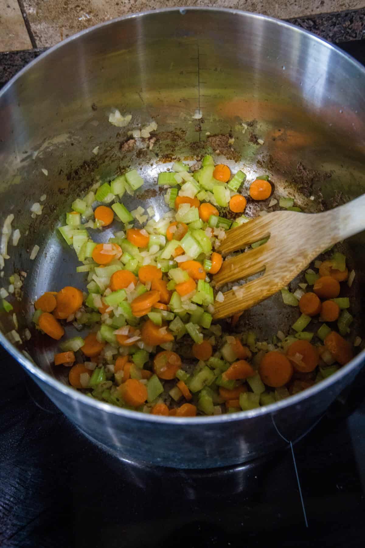 carrots celery and onions cooking in a pot