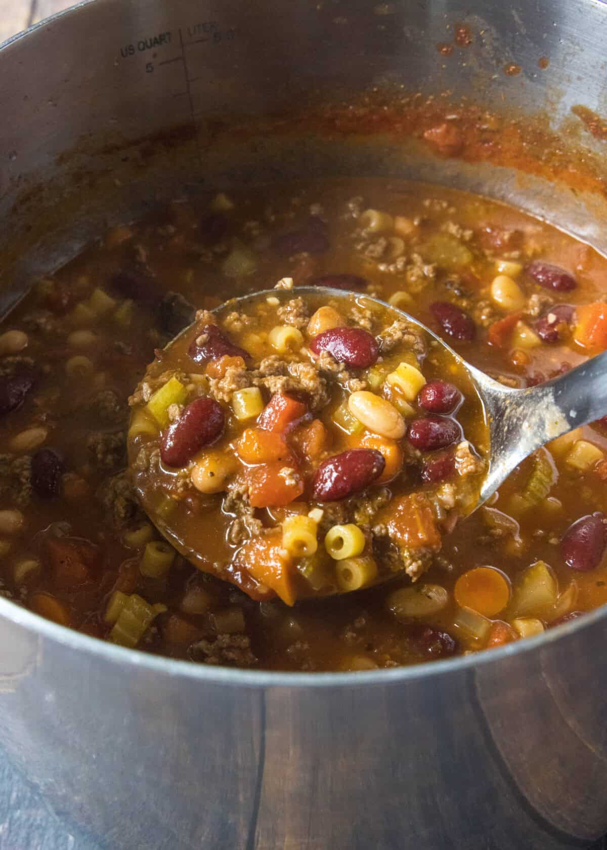 ladeling pasta fagioli out of a stockpot