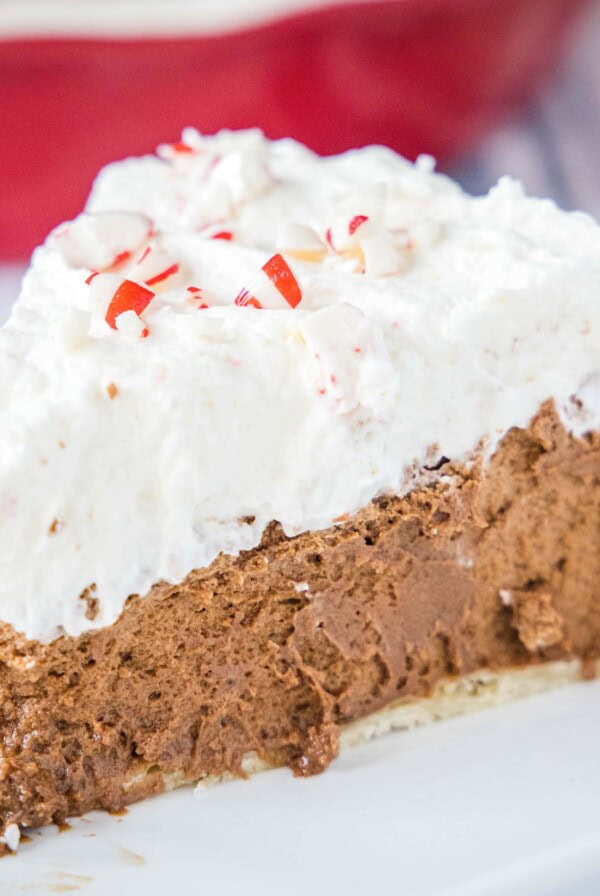 close up chocolate french silk pie with candy canes on a white plate