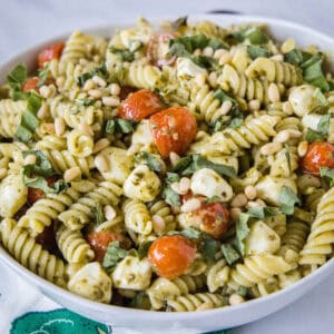 close up pesto pasta salad in a white bowl