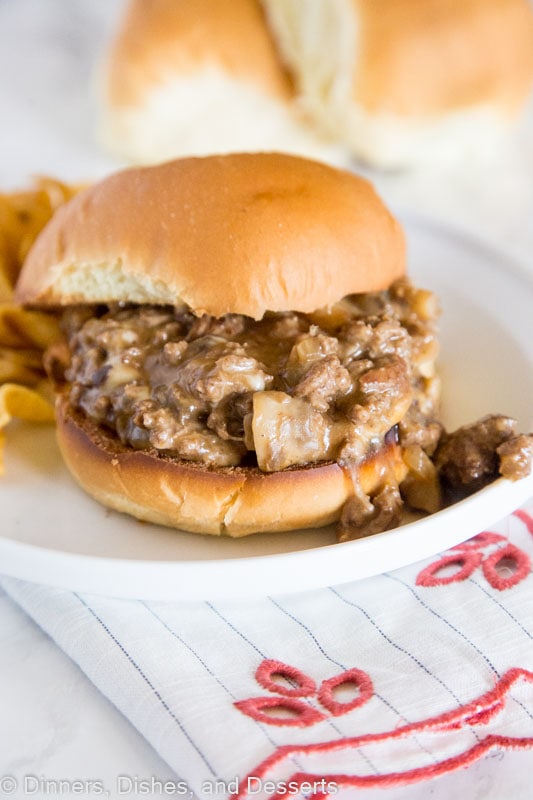 A sandwich sitting on top of a plate of food, with Dinner and Cheesesteak