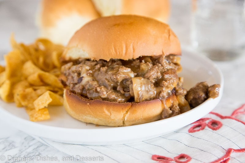 A sandwich sitting on top of a paper plate, with Dinner and Cheesesteak