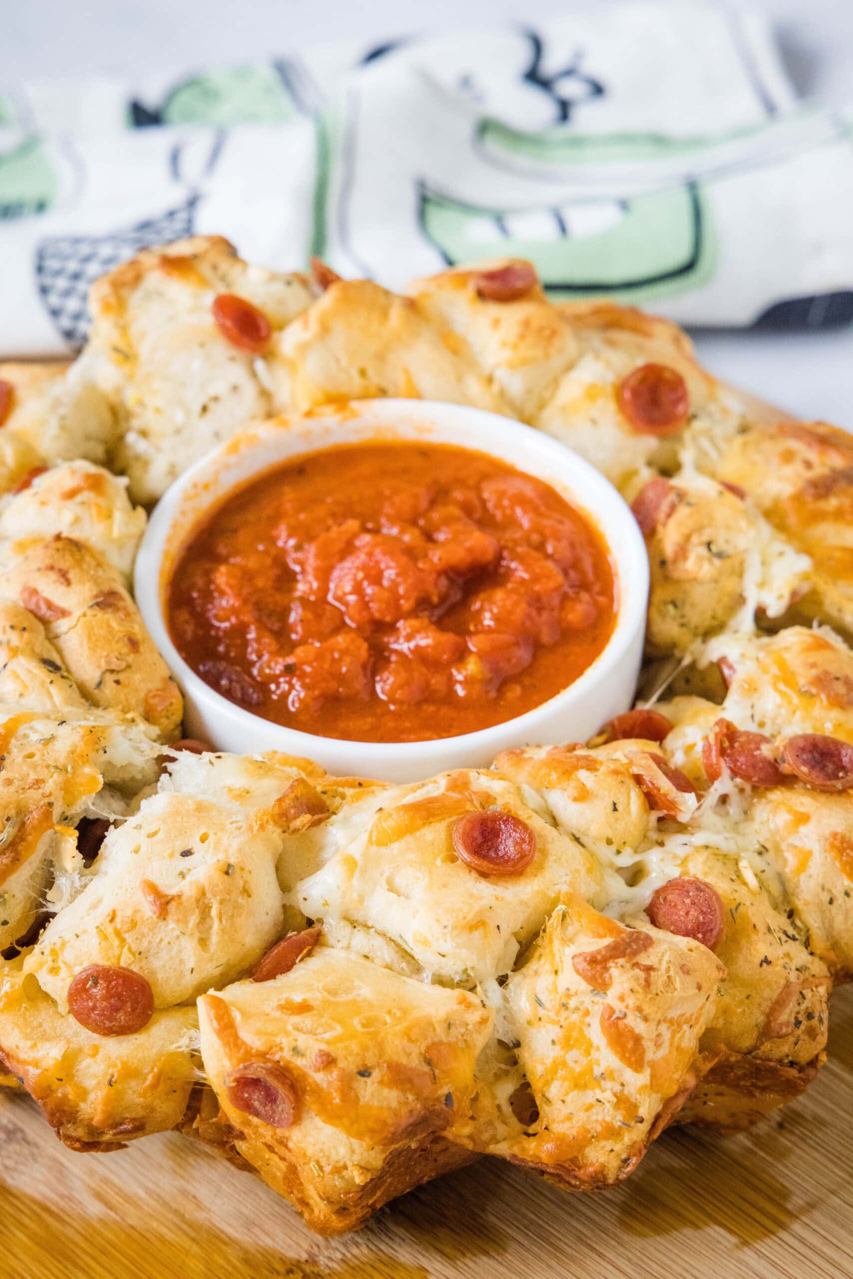 Pizza monkey bread with a bowl of pizza sauce in the middle hole.