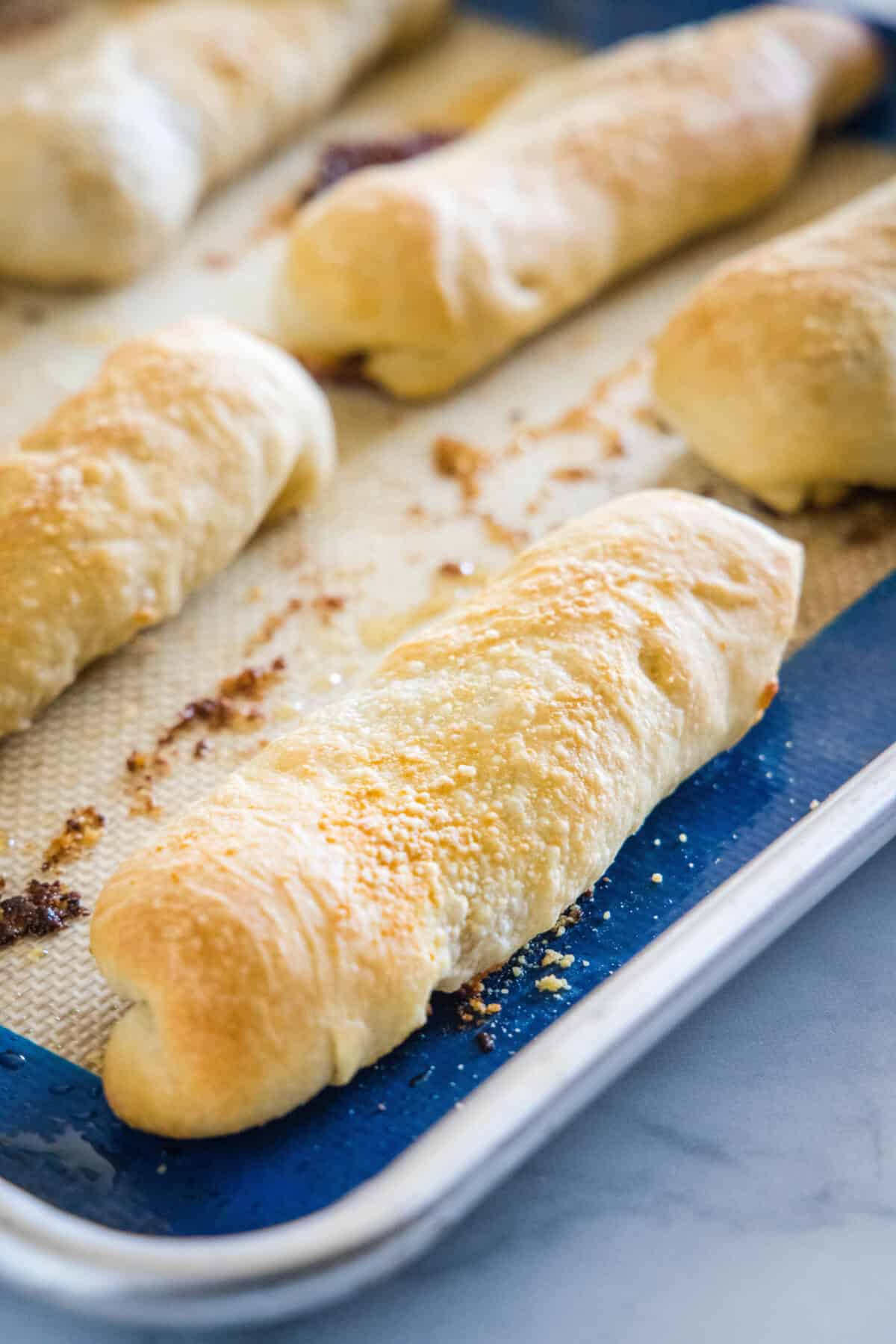 Baked pepperoni rolls on a lined baking sheet.