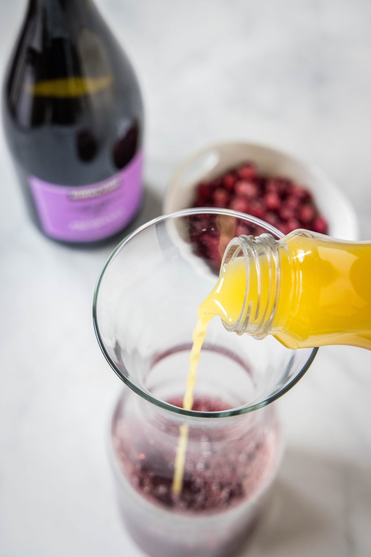 pouring orange juice into a pitcher