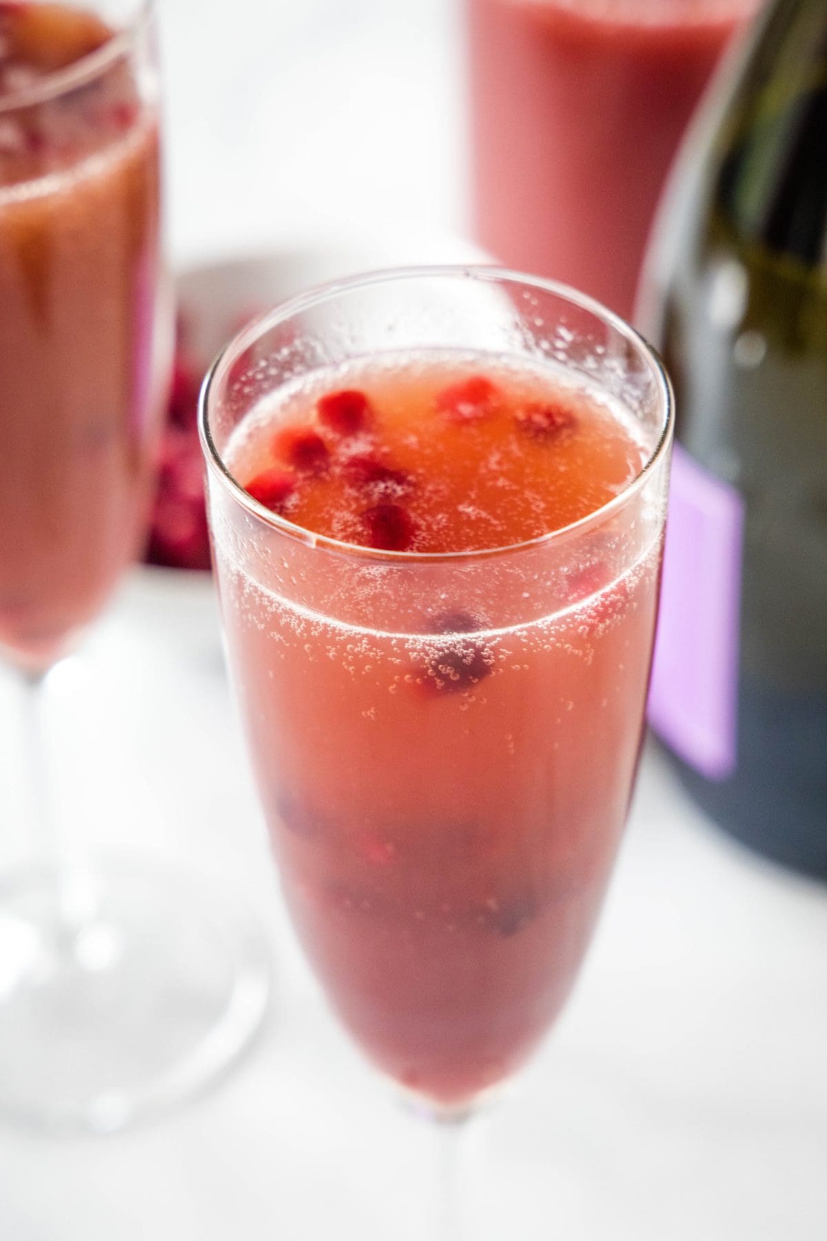 a champagne flute with pomegranate mimosa in it