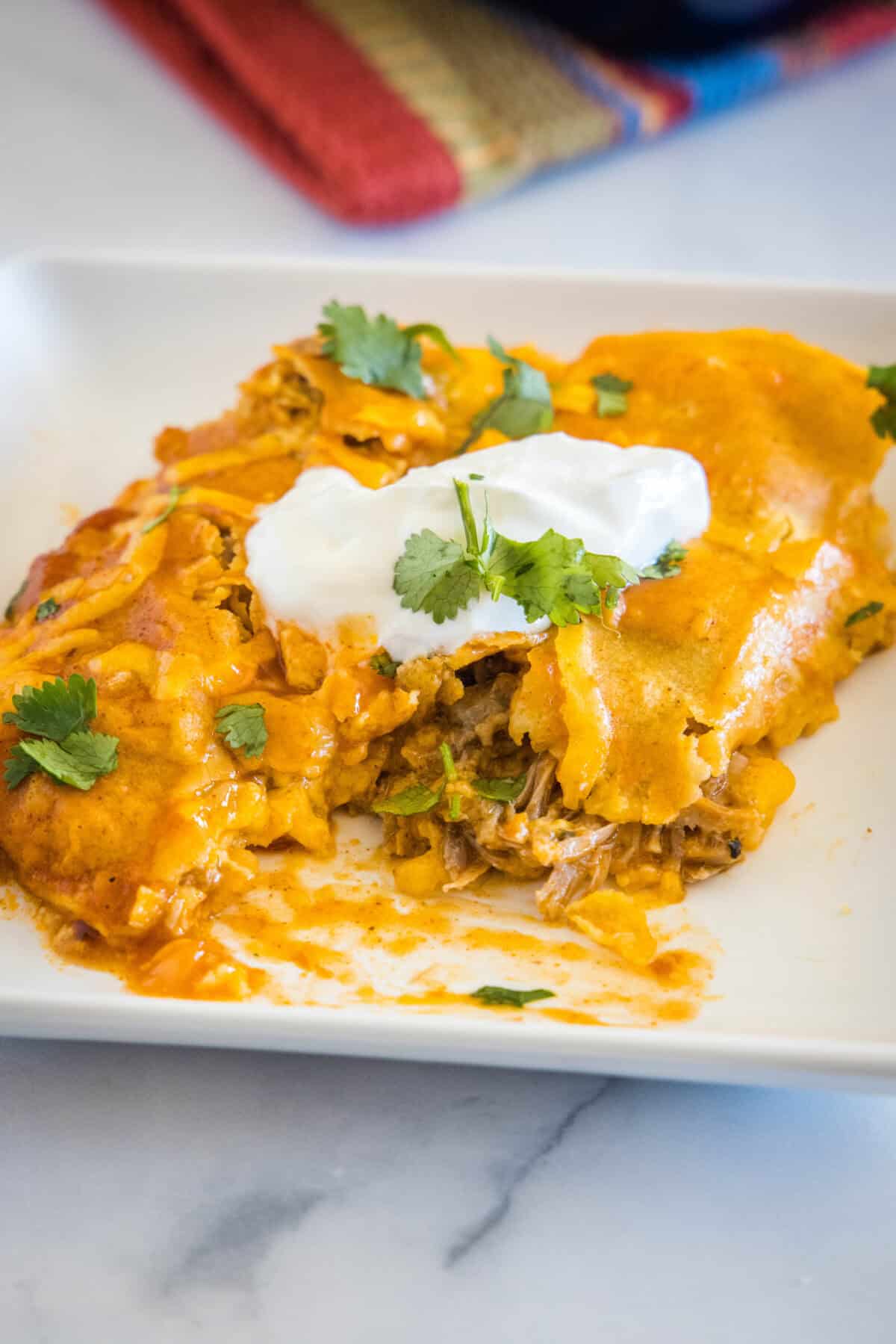 enchiladas on a plate with one cut in half