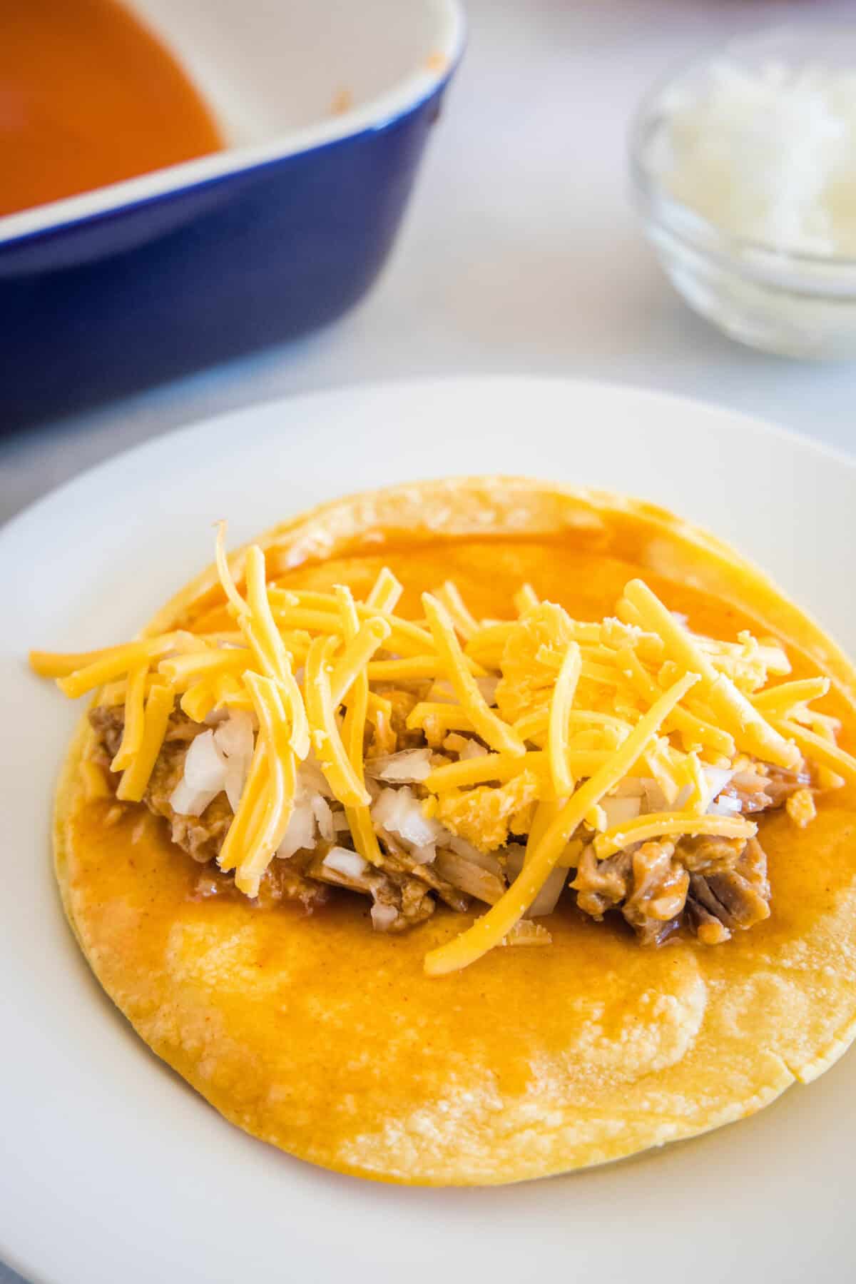 cheese, onions and pork on a corn tortilla