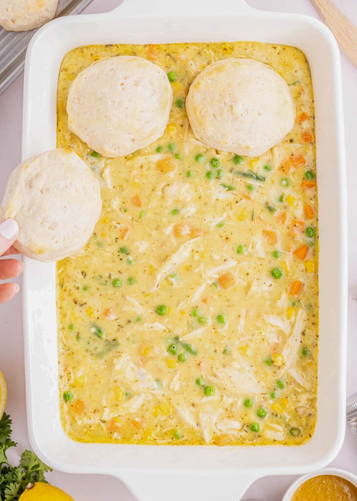 adding partially cooked biscuits to the top of the casserole