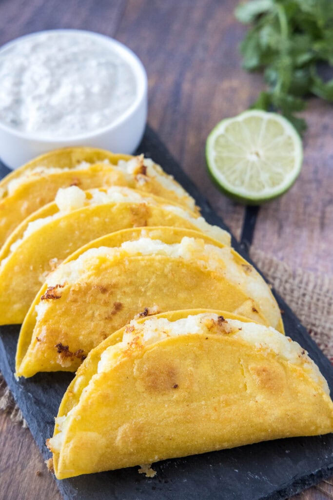 potato tacos on a tray with queso fresco dip