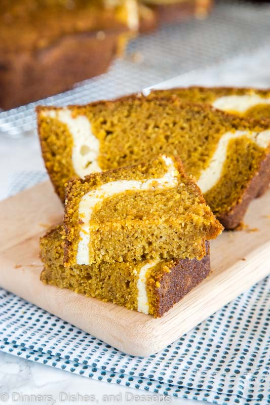 A slice of pumpkin bread with cream cheese swirl cut in half