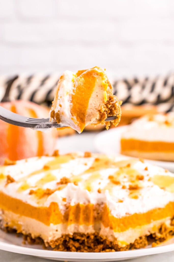 layered pumpkin dessert on a plate with a bite on a fork