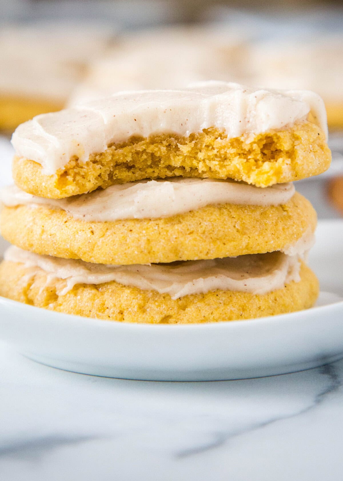pumpkin sugar cookies stacked on a plate