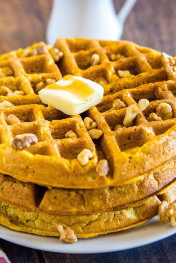 close up stack of pumpkin waffles with pat of butter on top