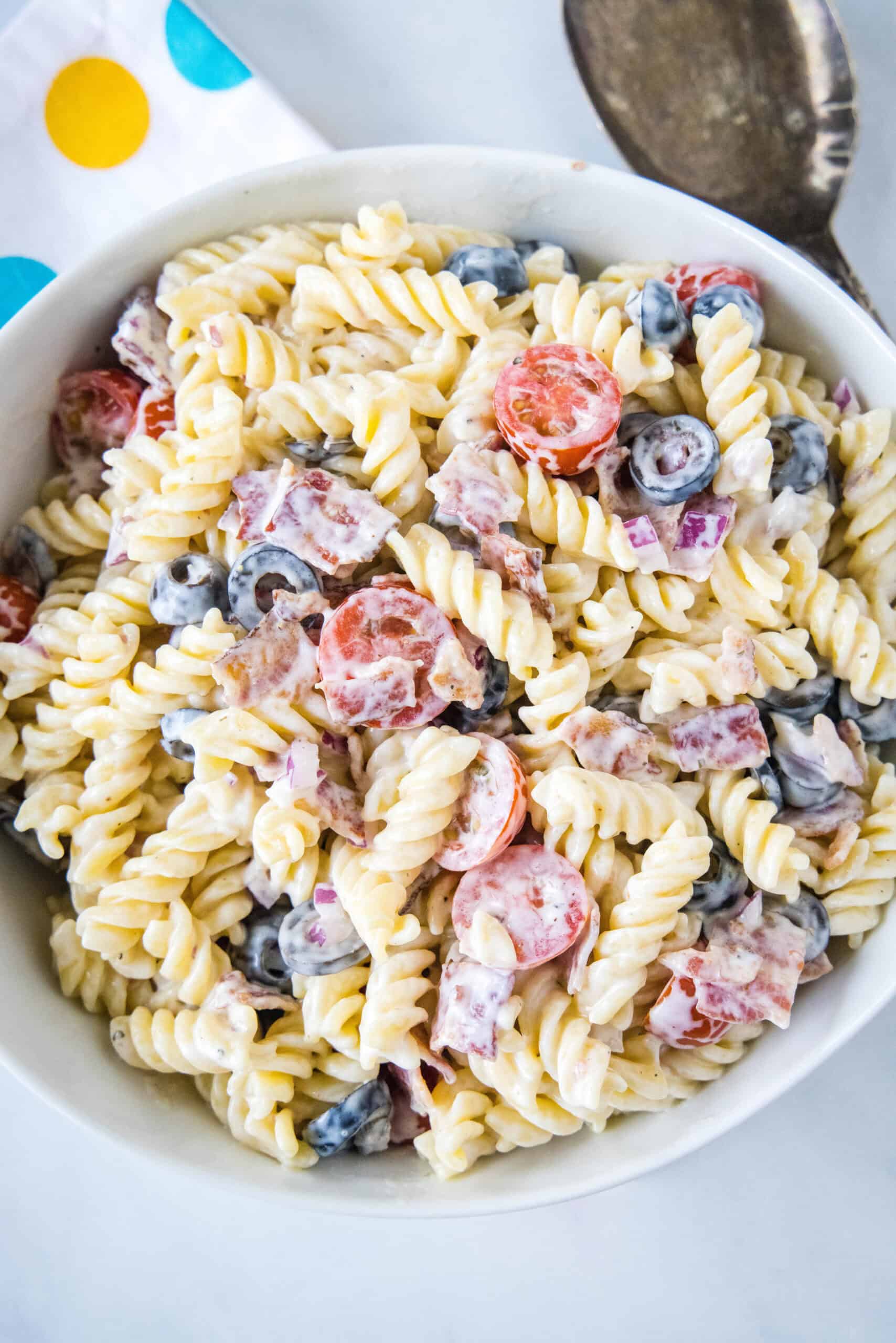 Overhead view of ranch pasta salad in a white bowl.