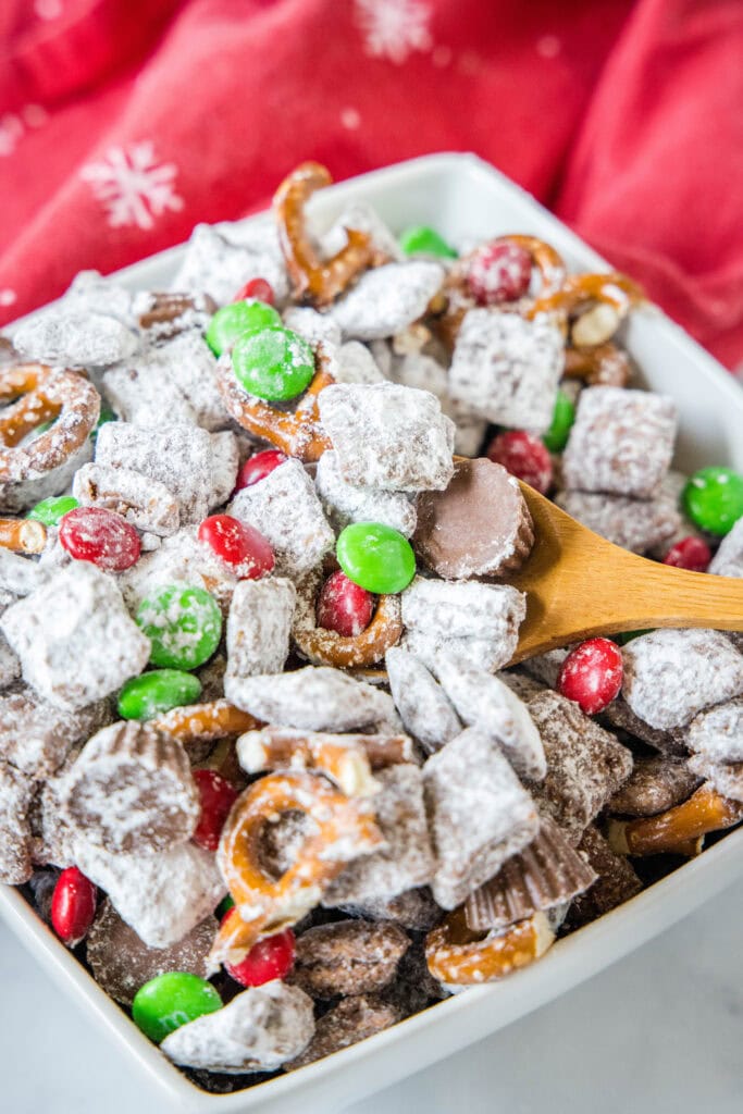 a spoon scooping reindeer muddy buddies out of a bowl