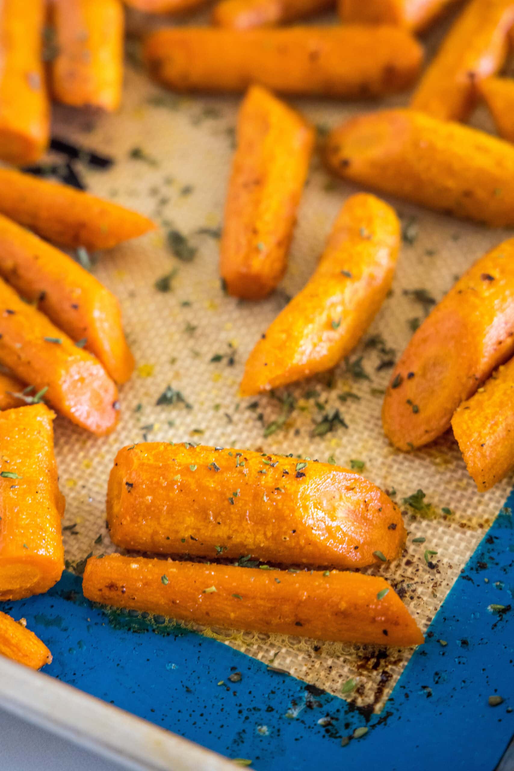 Seasoned roasted carrots on a baking sheet.