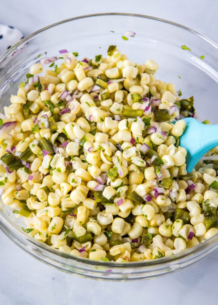 mixing together corn salsa ingredients