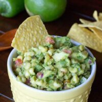 close up bowl of avocado corn salsa with tortilla chips