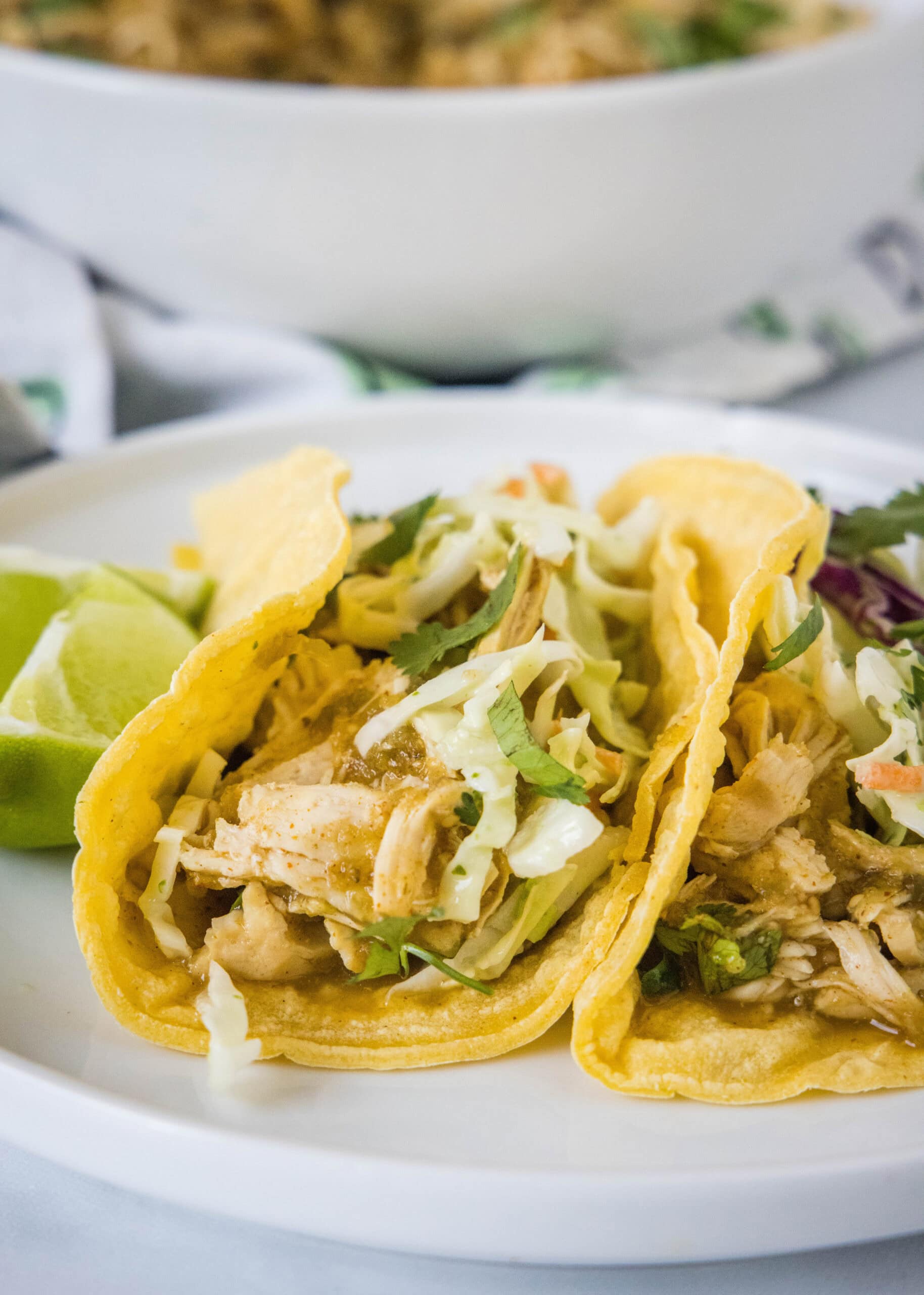 Two salsa verde chicken tacos on a white plate.