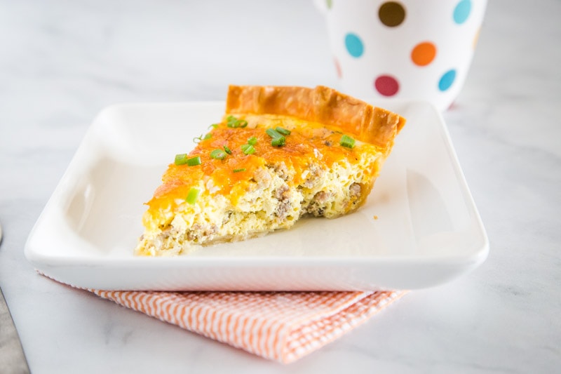 Sausage Quiche - An easy quiche recipe that is perfect for brunch or even a light dinner.  Flaky pie crust with an egg custard that is loaded with breakfast sausage, onions and plenty of cheddar cheese.
