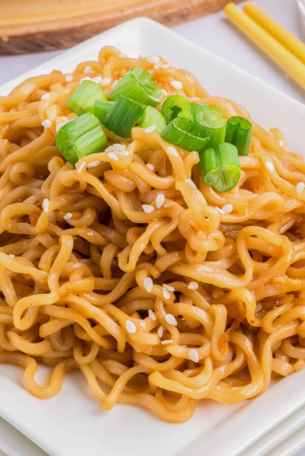 cropped close up sesame noodles on a plate with green onions