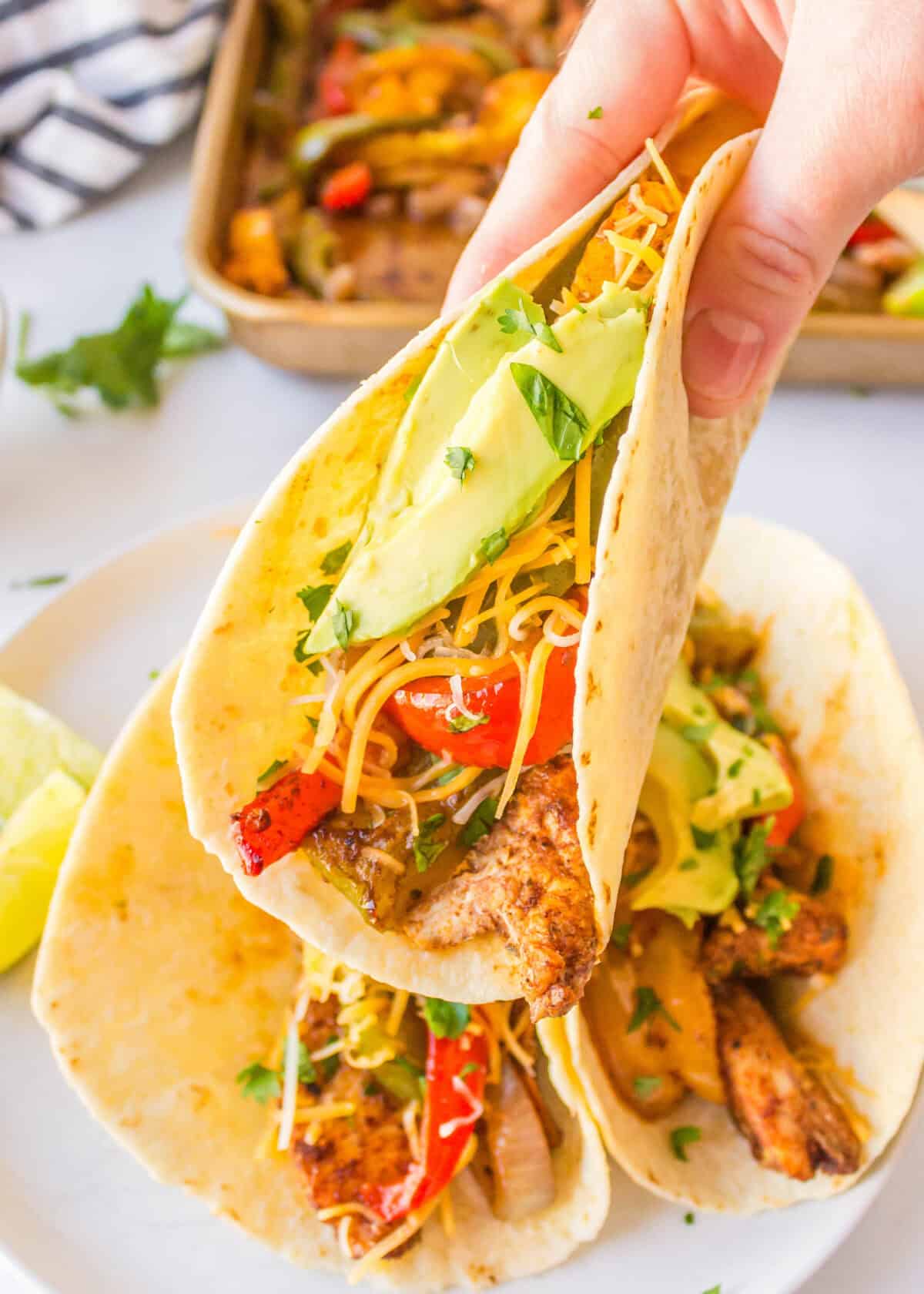 lifting up a chicken fajita off a plate