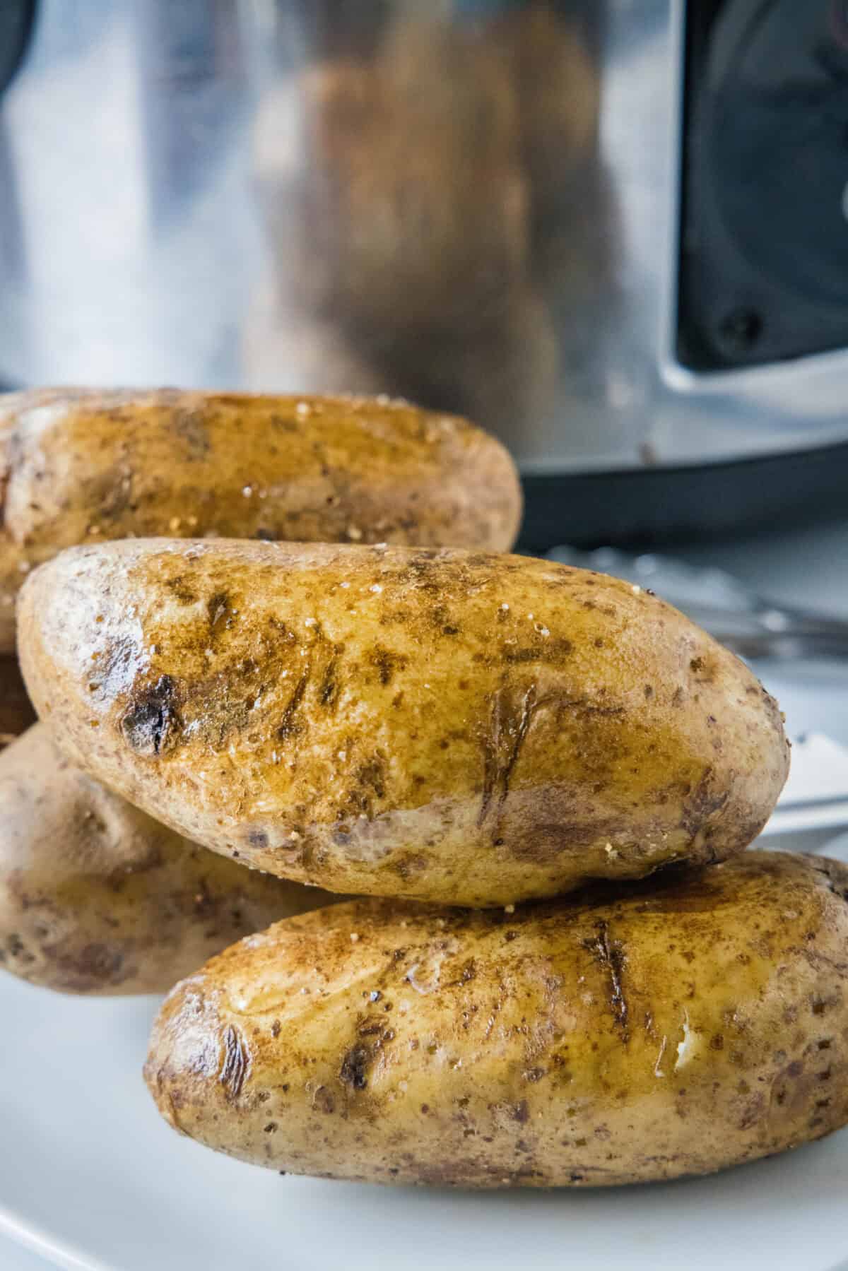 cooked baked potatoes in front of crockpot