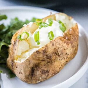 cropped close up slow cooker baked potatoes topped with sour cream