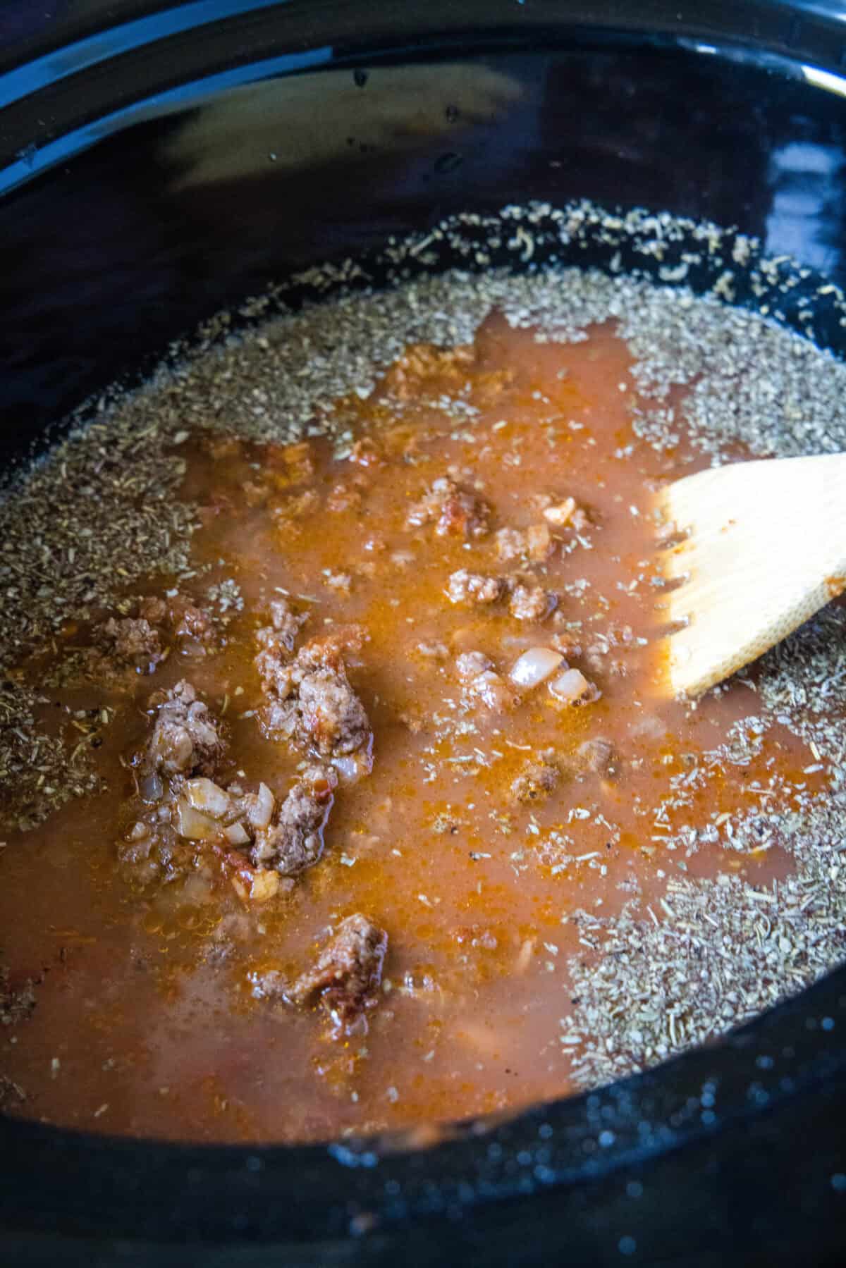 adding ground beef and tomato products to a crockpot