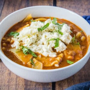 close up slow cooker lasagna soup in a white bowl
