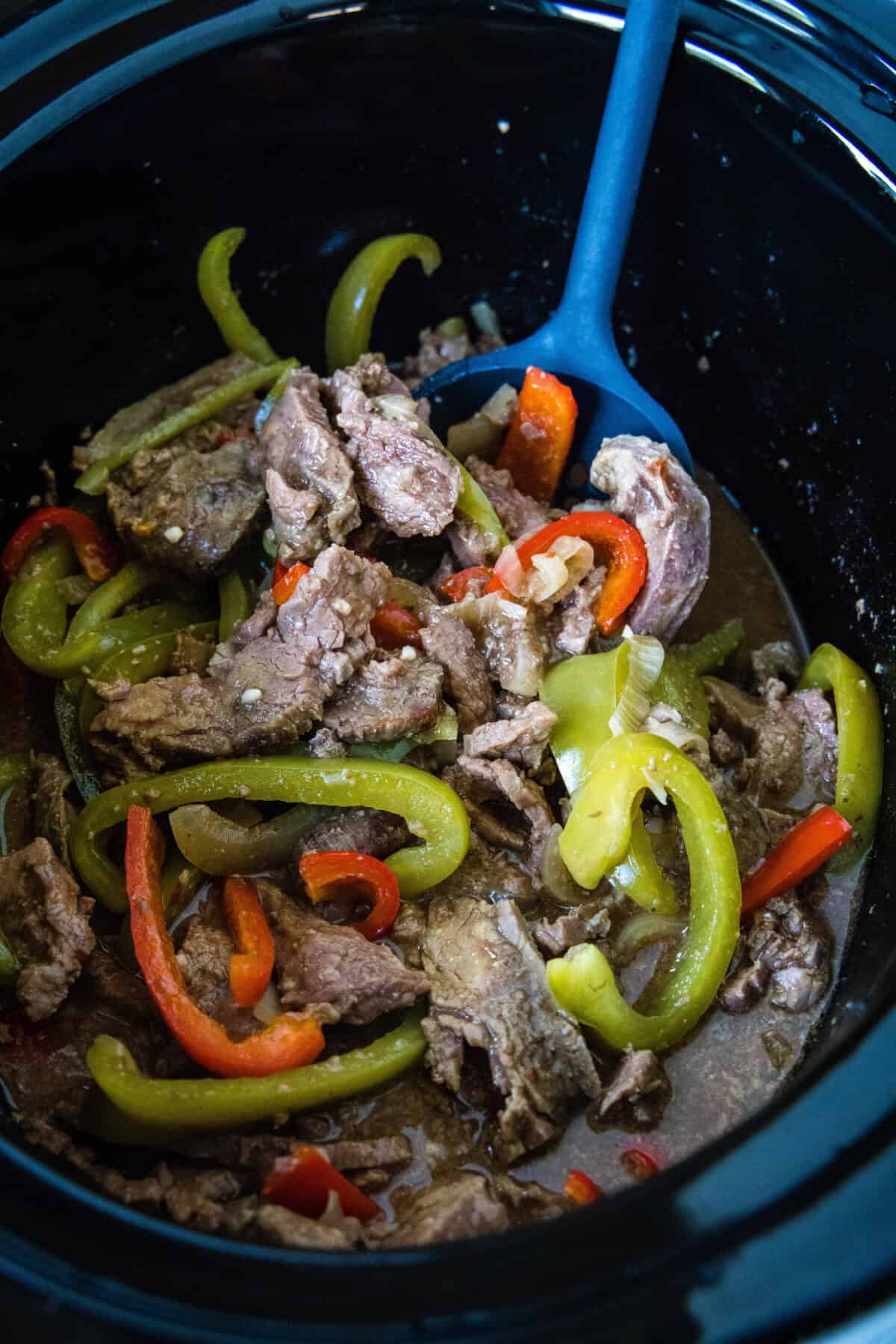 scooping pepper steak out of crockpot