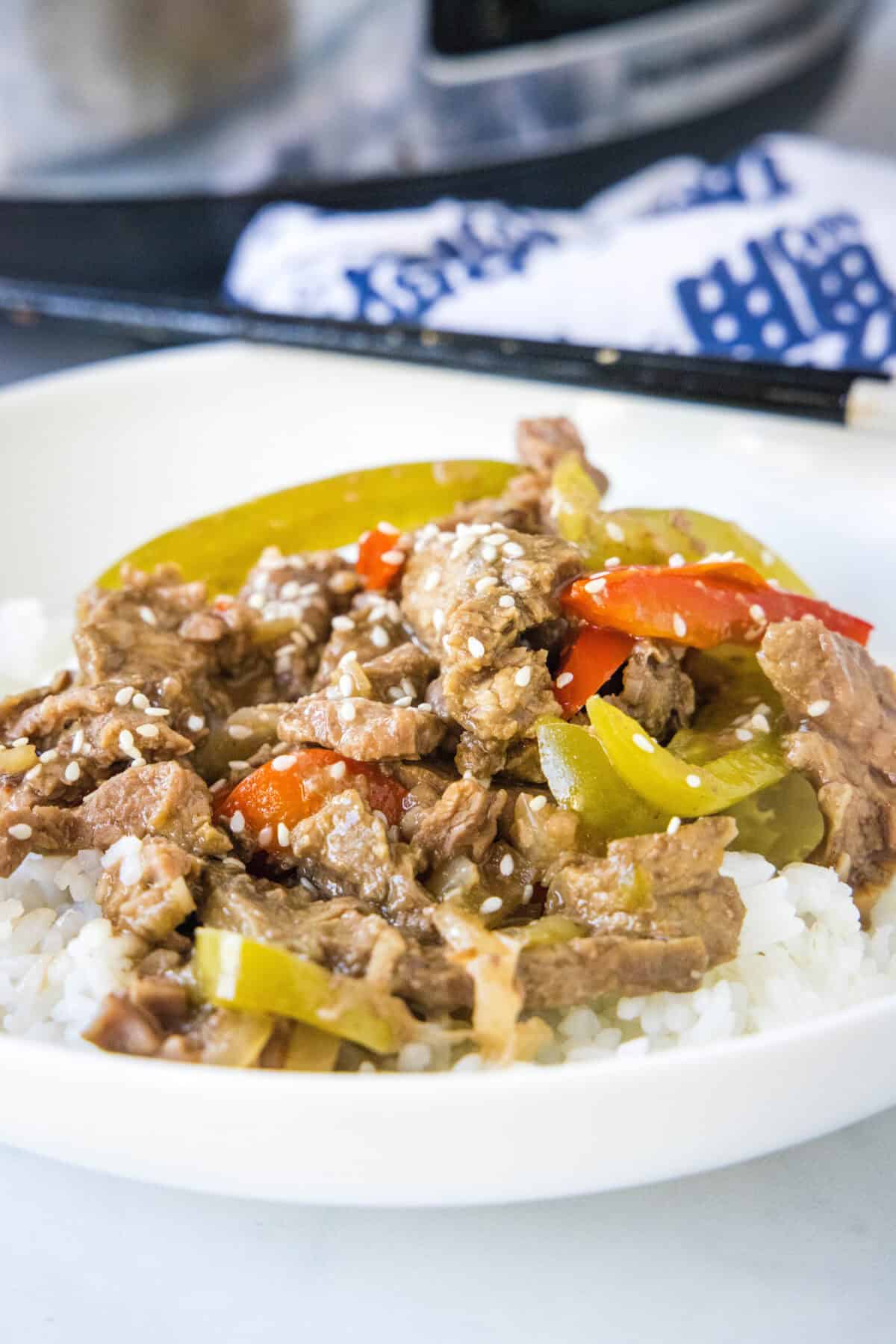 slow cooker pepper steak over rice on a plate