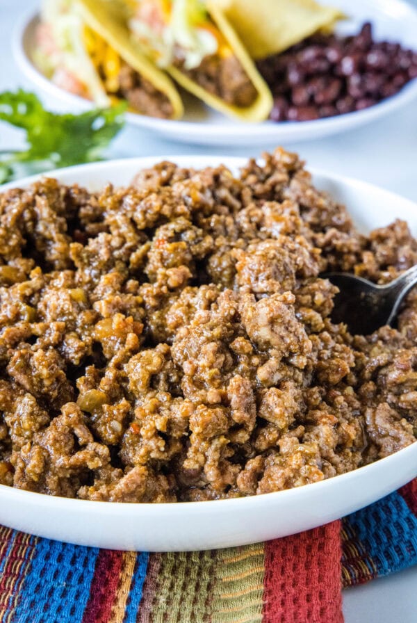 Slow cooker taco meat in a large white bowl.