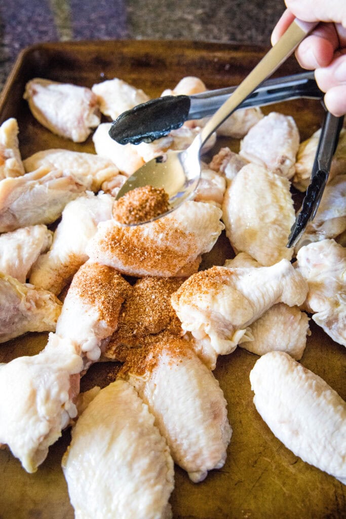 adding spice rub to chicken wings